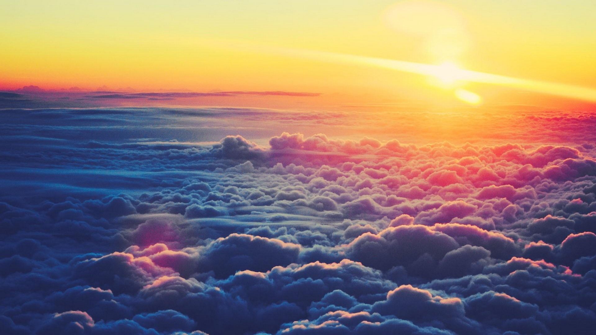 Sunrise casts a warm glow over a sea of clouds, highlighting the natural beauty of the sky and creating a serene, peaceful atmosphere.