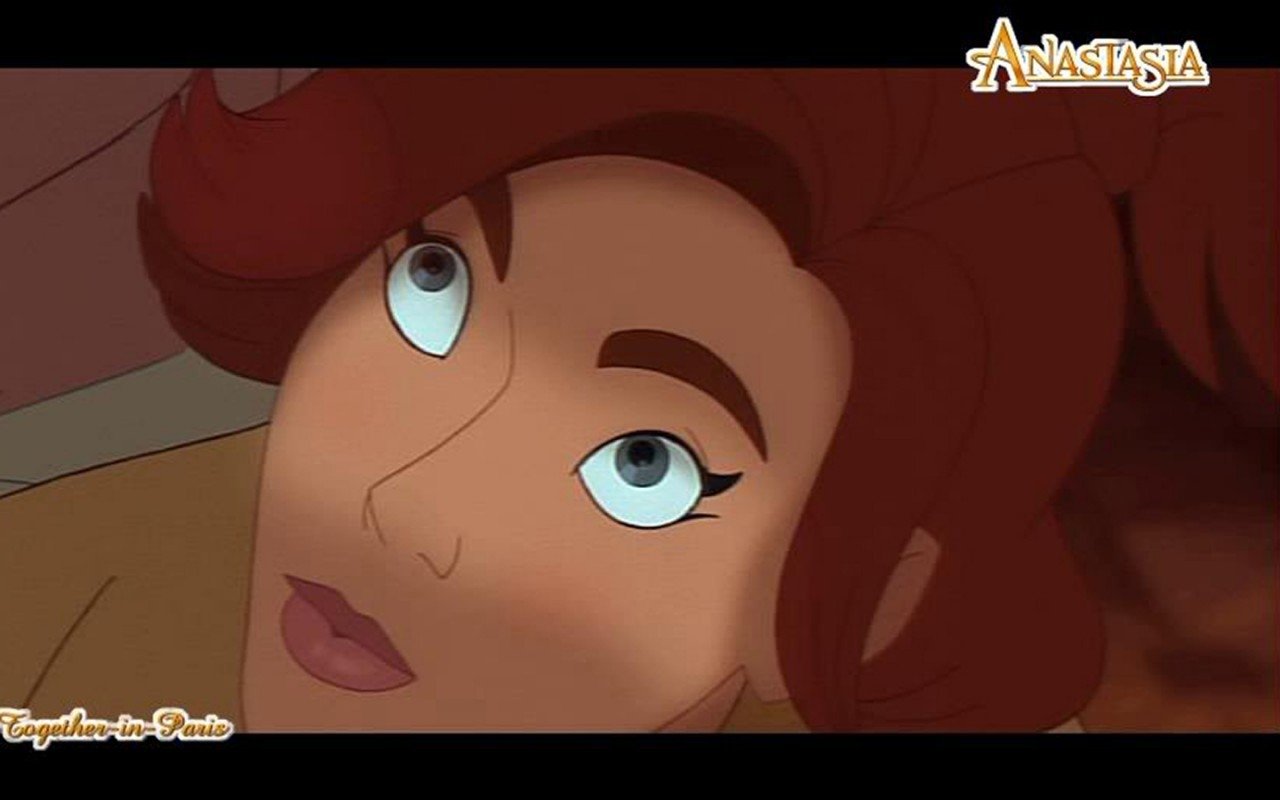 Close-up of Anastasia from the animated movie Anastasia, showing her with red hair and blue eyes looking upward thoughtfully.