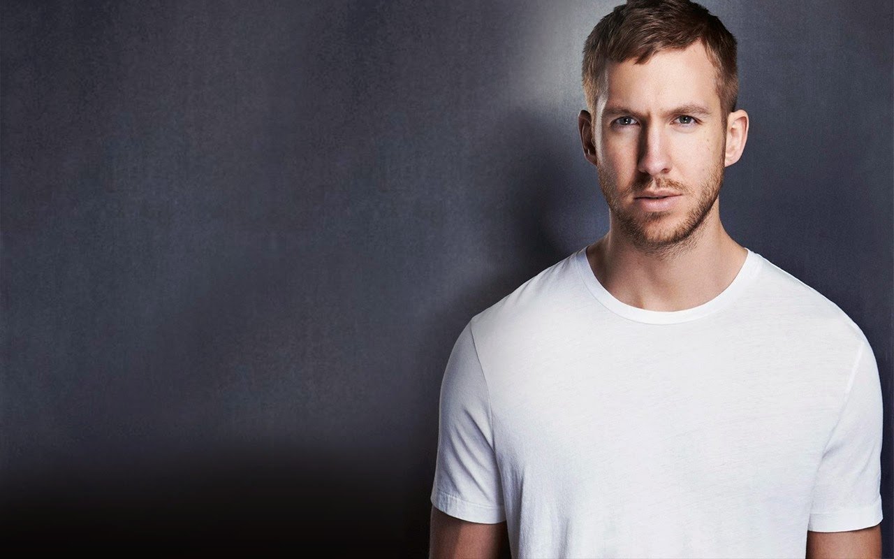 Calvin Harris poses confidently in a minimalist setting, showcasing his signature style. The image reflects his status in the music industry.
