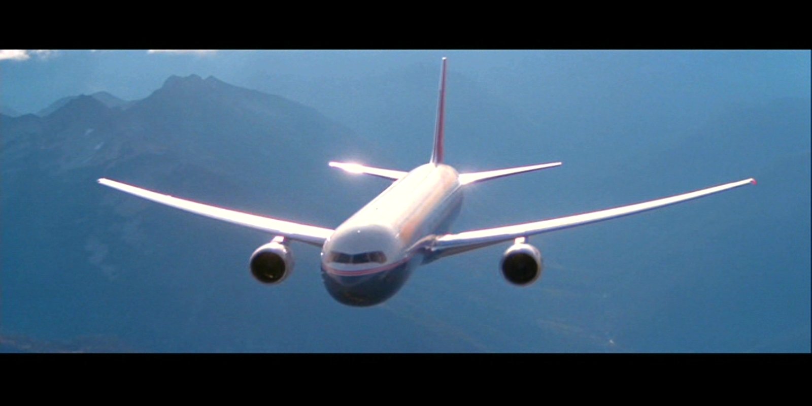 A commercial airplane flies against a mountainous backdrop in a scene from the movie World War Z.