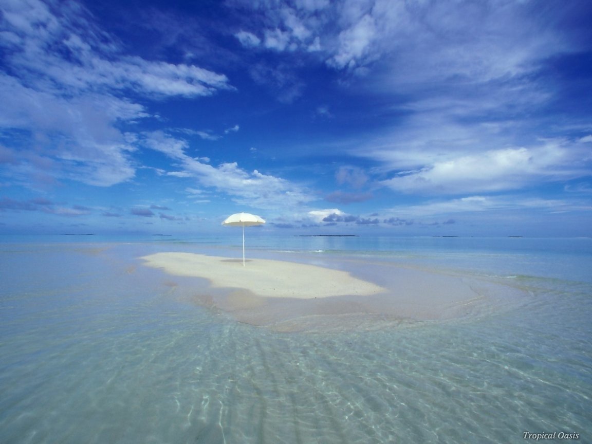 A serene island scene features a lone umbrella atop a sandy patch, surrounded by tranquil waters and a vibrant blue sky, capturing the essence of nature's beauty.