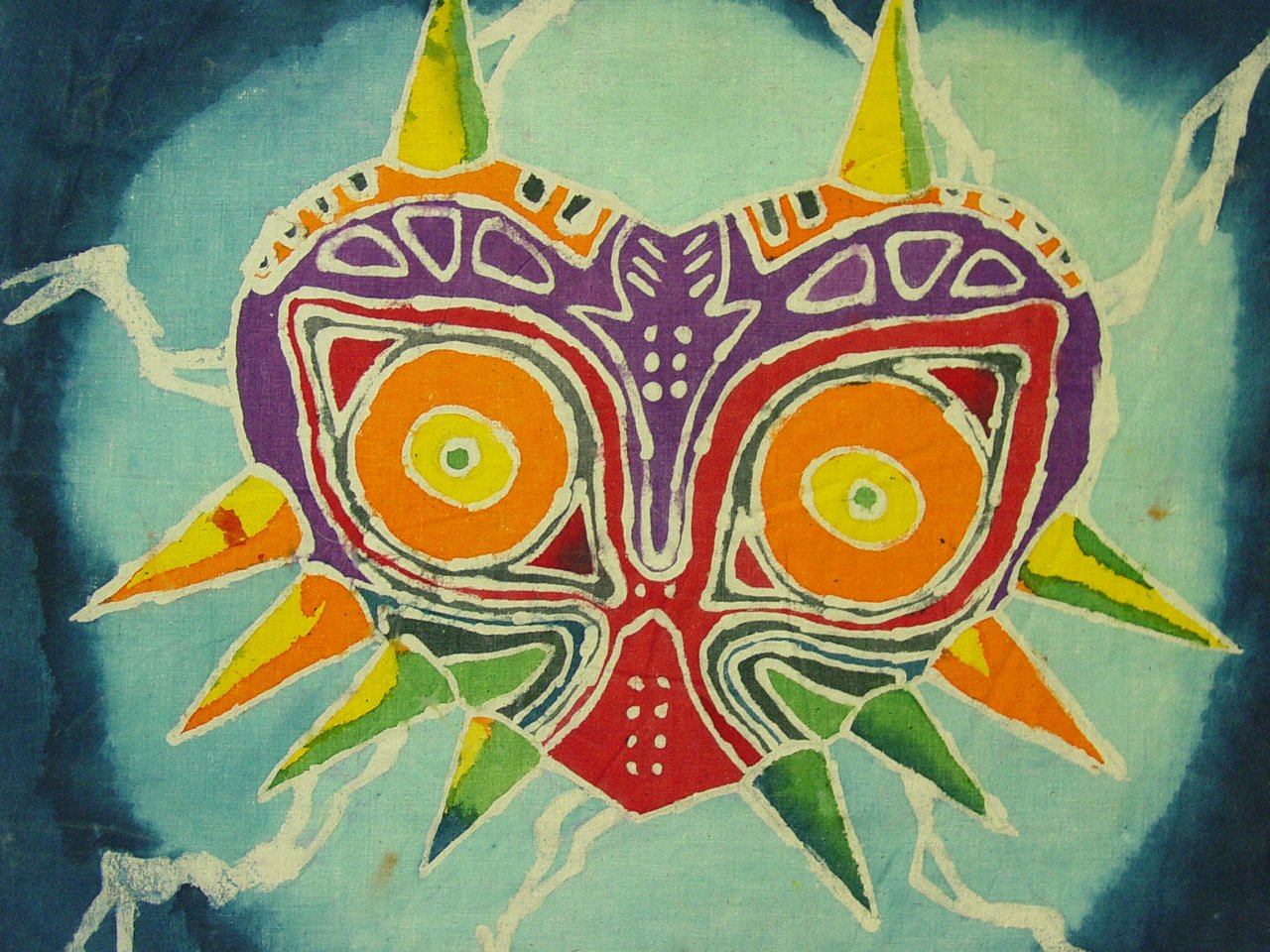 Artwork featuring the iconic skull mask from The Legend of Zelda: Majora's Mask, characterized by vibrant colors and sharp spikes against a blue background.