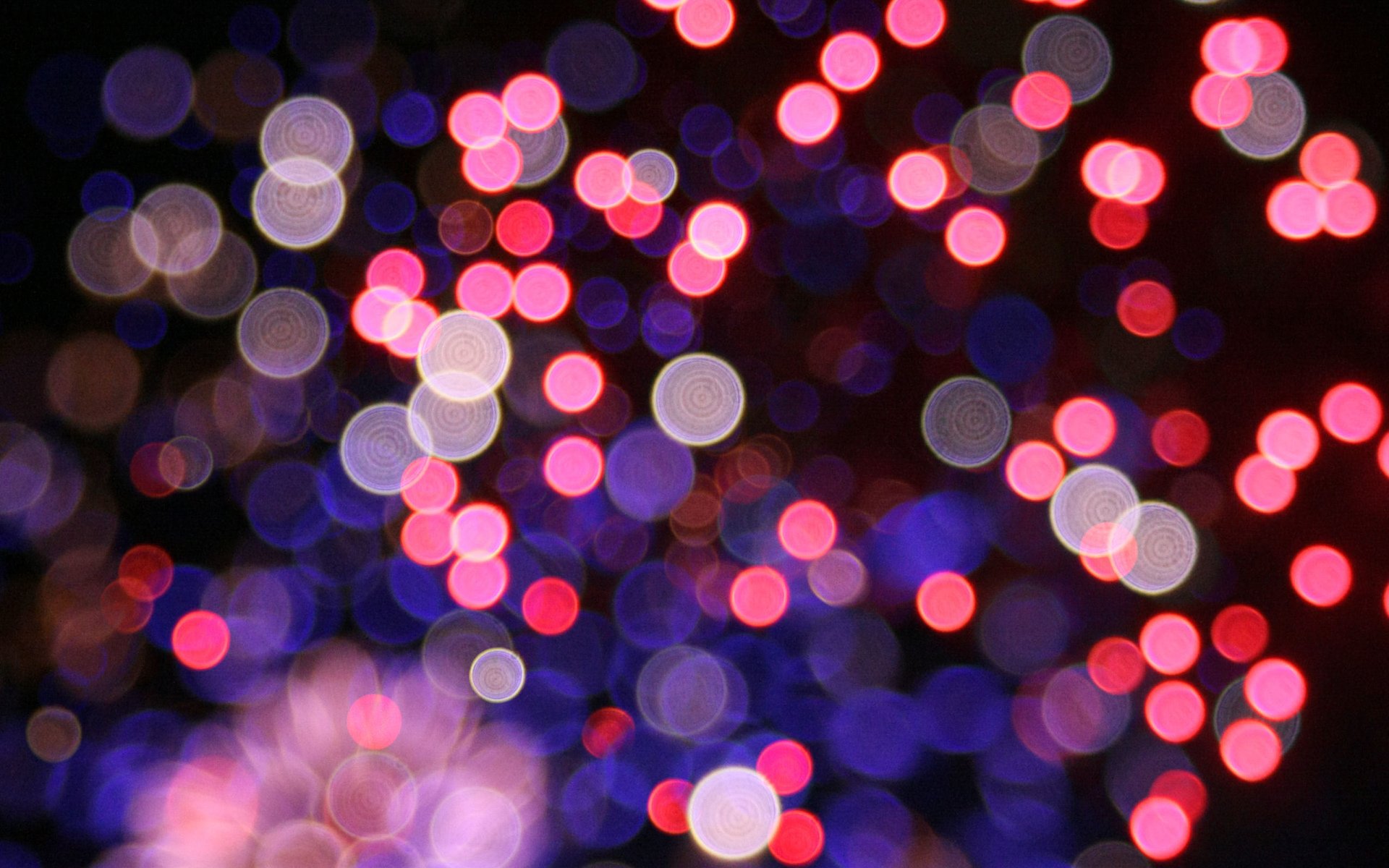 Abstract image featuring overlapping circles of light in vibrant pink, purple, and white hues against a dark background.