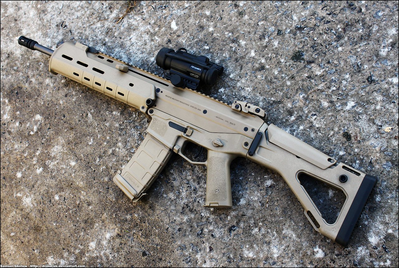 A tan man-made assault rifle rests on a gravel surface, featuring a modern design and a mounted optic for enhanced aiming capability.
