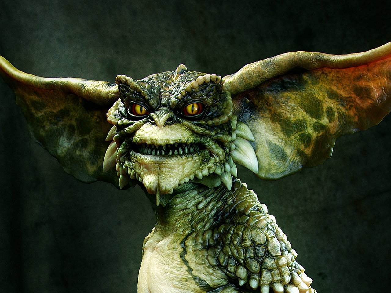 A detailed close-up of a Gremlin creature from the movie Gremlins, showing its textured skin, large ears, sharp teeth, and intense yellow eyes against a dark background.