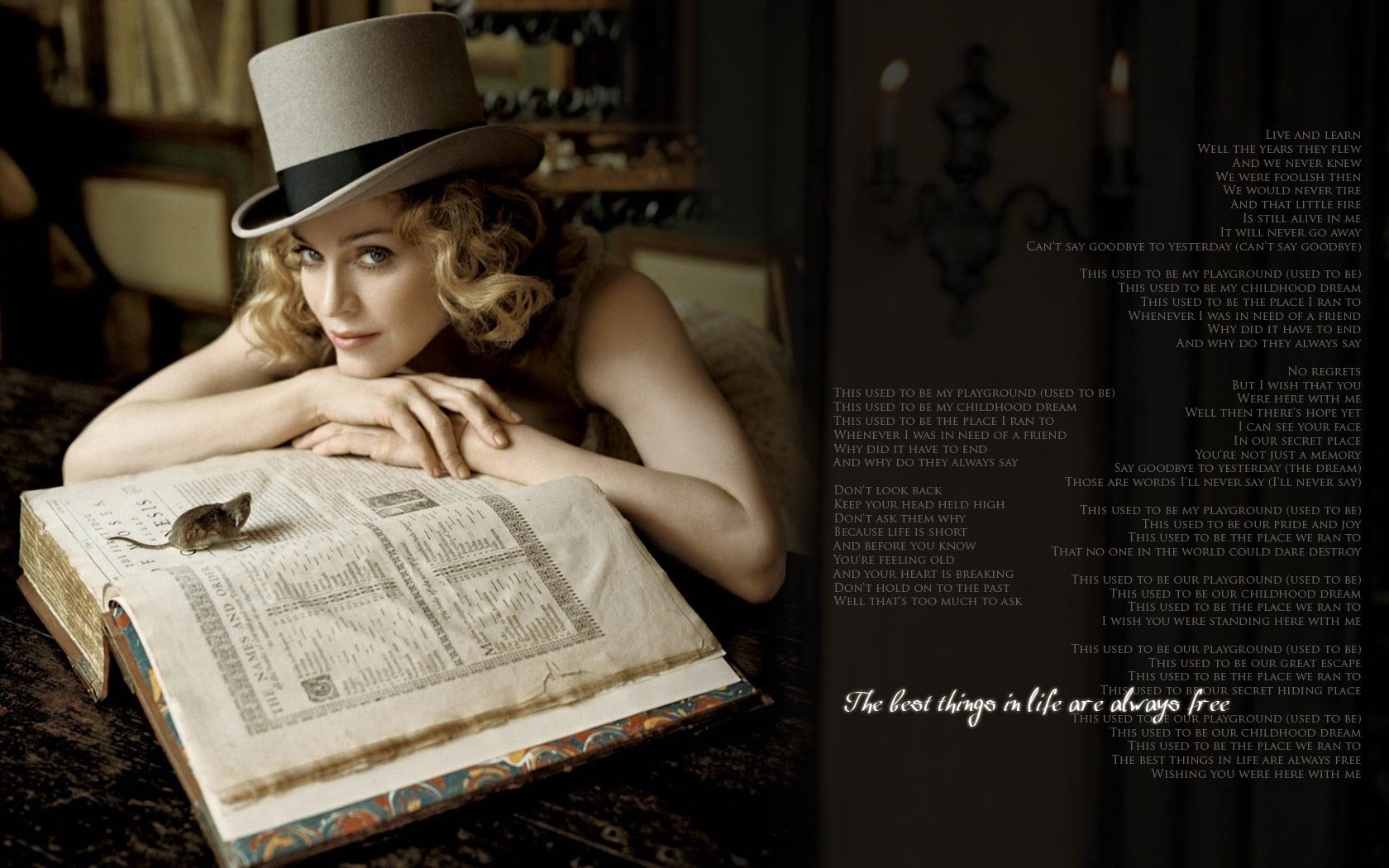 A woman in a top hat rests her chin on an open book, surrounded by a lavish setting. The image reflects themes of music and artistry, featuring elements of Madonna's iconic style.