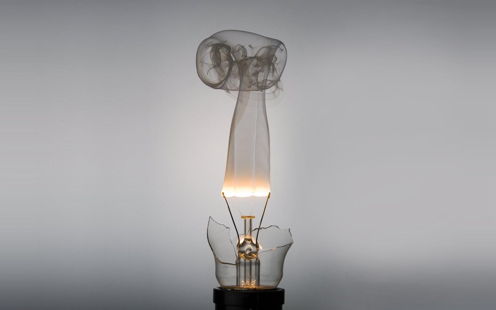 A unique light bulb design featuring a delicate glass structure, emitting a soft glow, showcasing the creativity of man-made innovation in lighting.