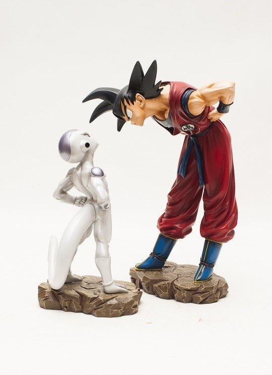 A dynamic scene from Dragon Ball Z featuring Goku and Frieza, showcasing their iconic rivalry with detailed figures positioned dramatically against a neutral background.