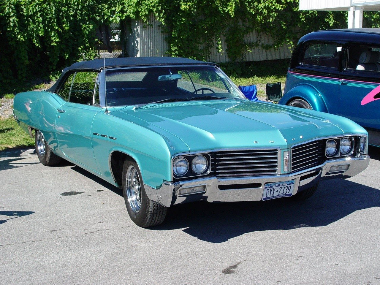 A turquoise 1967 Buick LeSabre convertible parked outdoors on a sunny day, showcasing its classic design and chrome details.