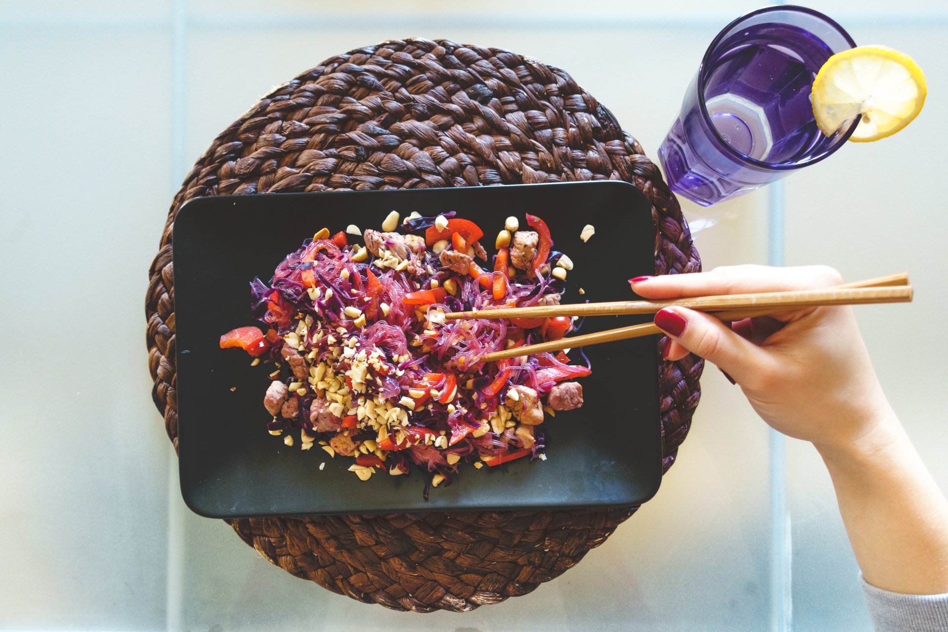  Woman eating beet glass noodles by Jakub Kapusnak