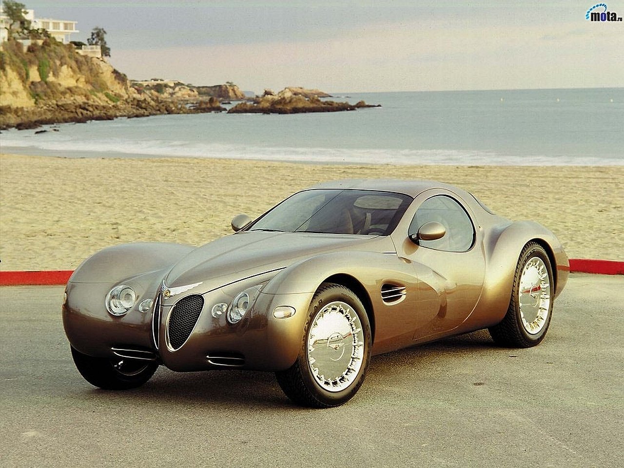 A sleek 1995 Chrysler Atlantic Concept Car parked by the beach, showcasing its futuristic and aerodynamic design with smooth curves and chrome details.