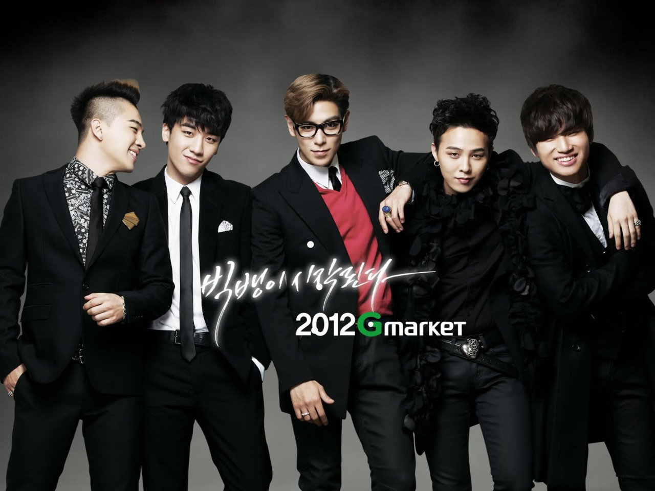 A stylish group portrait of the music group Bigbang, showcasing their unique fashion and confident poses, set against a dramatic background. The image promotes a Gmarket collaboration from 2012.