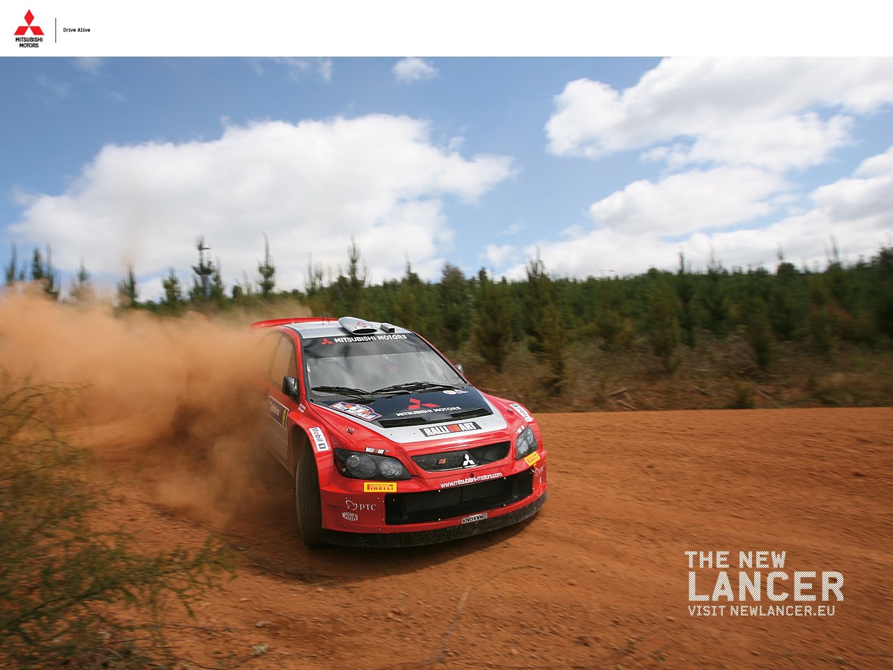 A Mitsubishi Lancer Evolution kicks up dust as it navigates a rugged dirt path, showcasing its performance capabilities amidst a backdrop of trees and a blue sky.