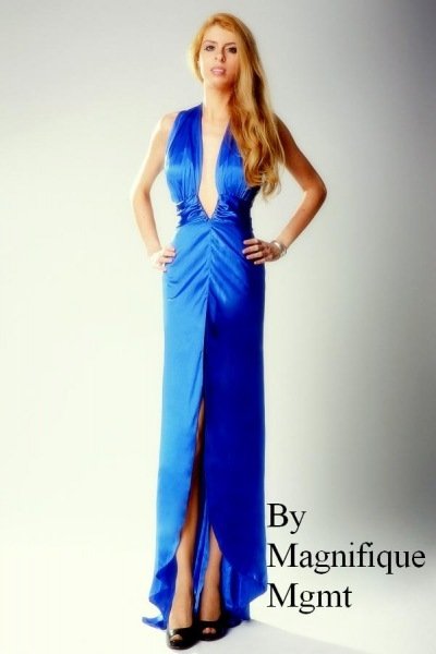 Model Miss Summer poses confidently in a deep blue gown with a high slit, photographed by Kamila Wojtulewicz for By Magnifique Mgmt.