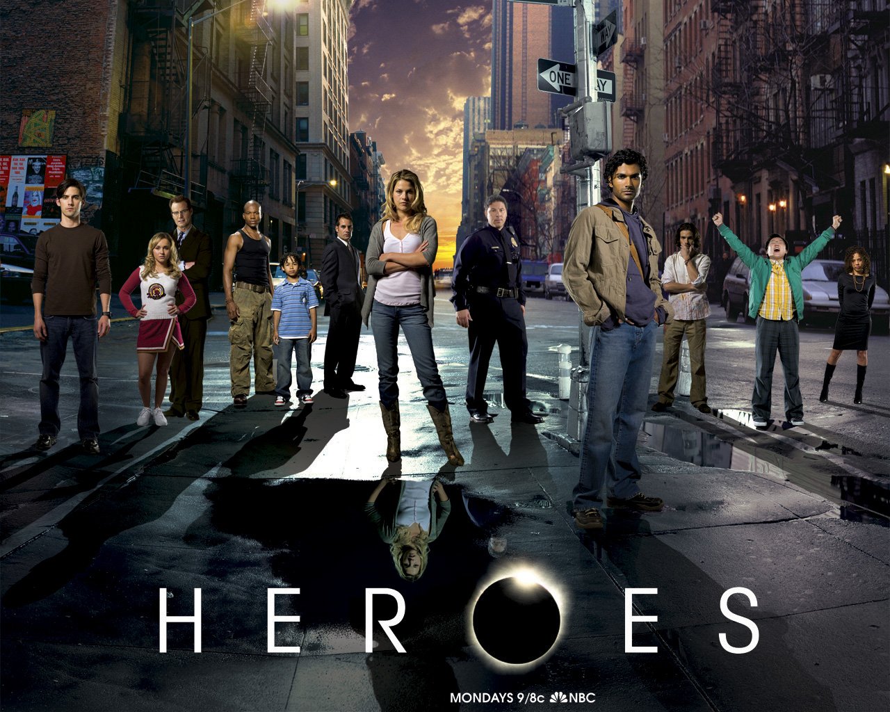 A diverse group of characters stands dramatically on a city street, representing the TV show Heroes, which explores the lives of people with extraordinary abilities.