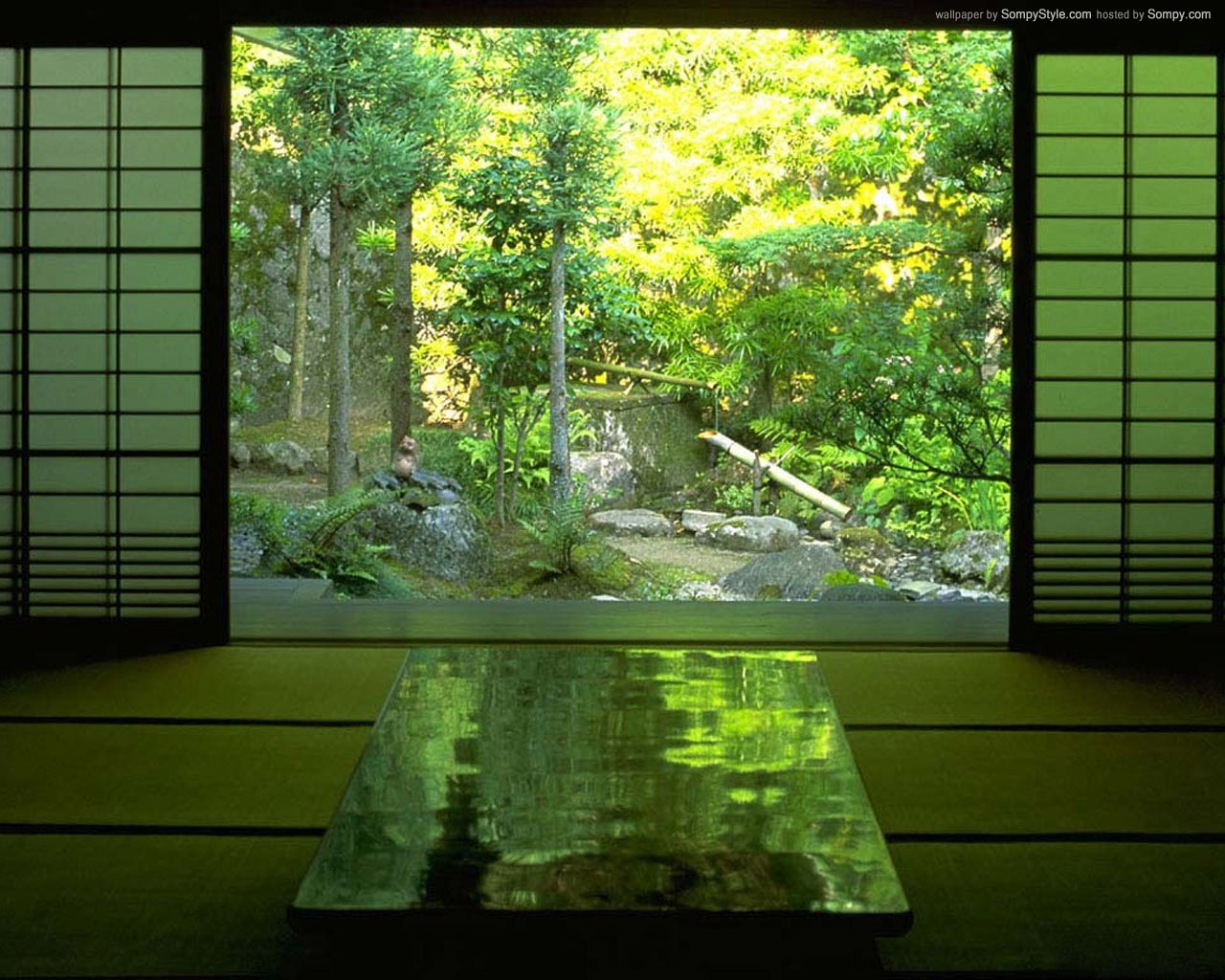 A serene room featuring a polished table, with sliding shoji doors revealing a lush green garden and tranquil landscape beyond. Nature and man-made elements harmoniously coexist.