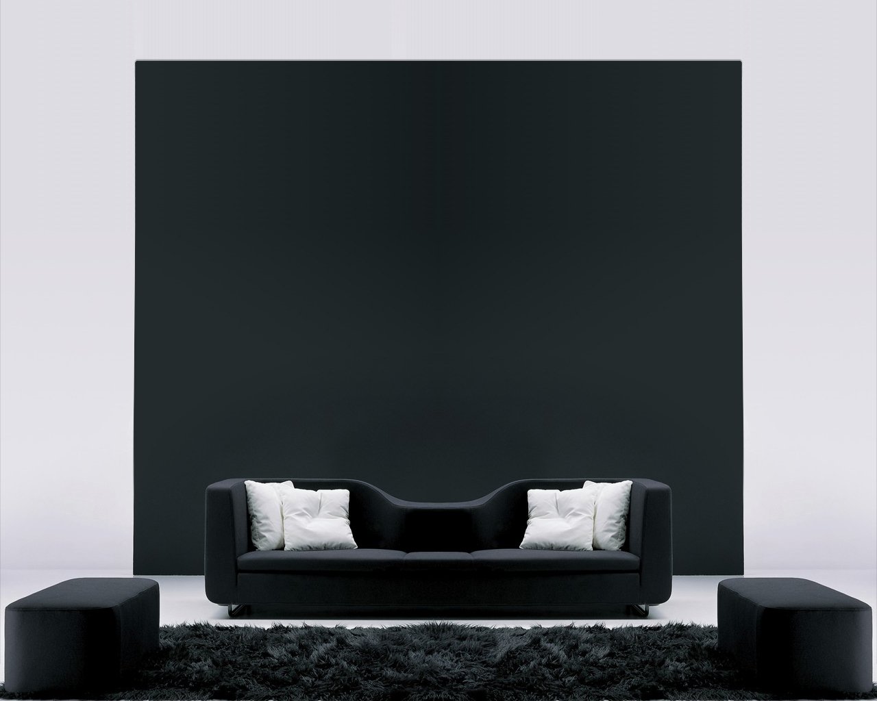 A modern living room features sleek black furniture, including a curved sofa and matching benches, set against a dramatic black wall and soft textured rug.