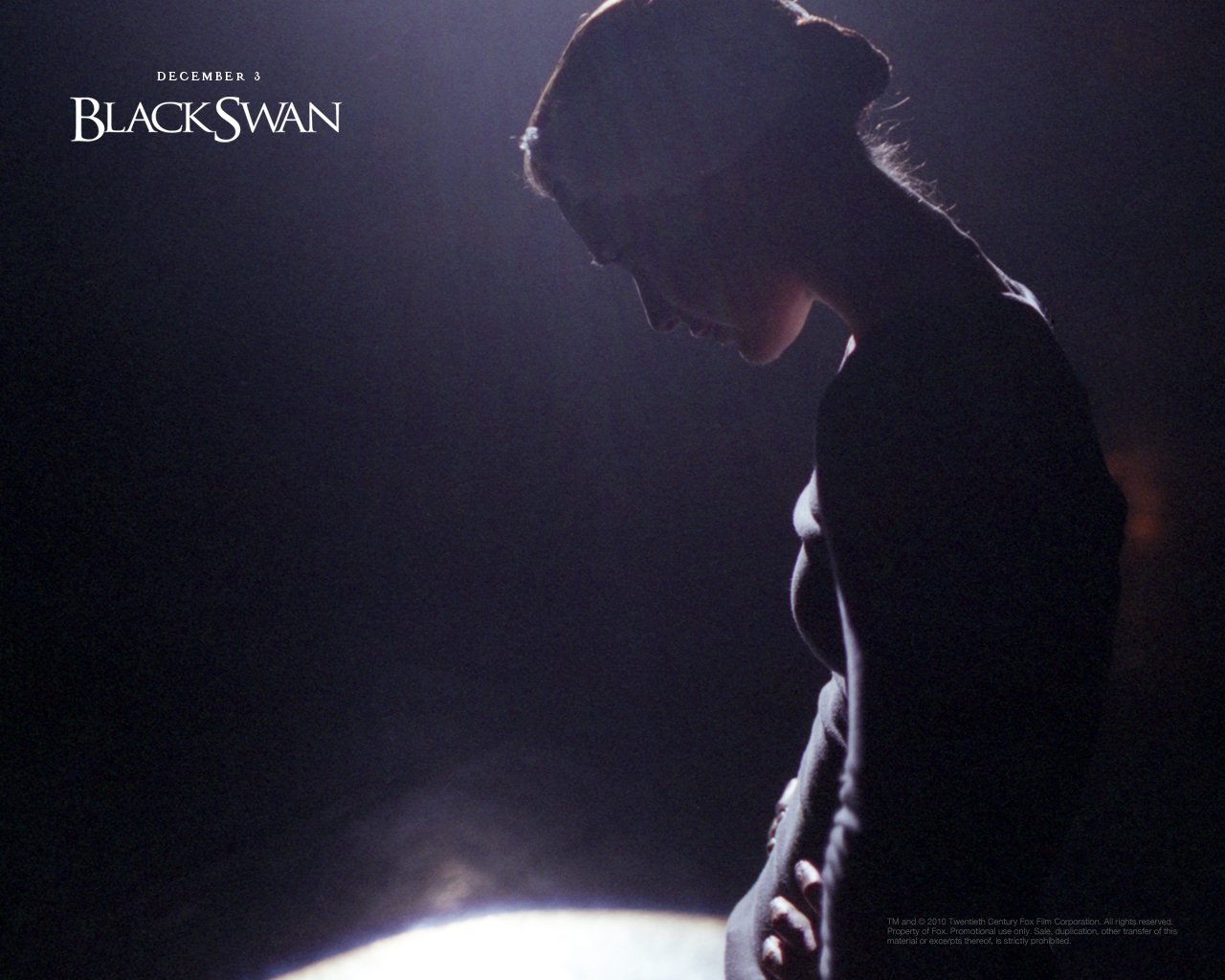 Silhouette of a woman in profile, illuminated by soft light, with the title Black Swan indicating the movie release on December 1.