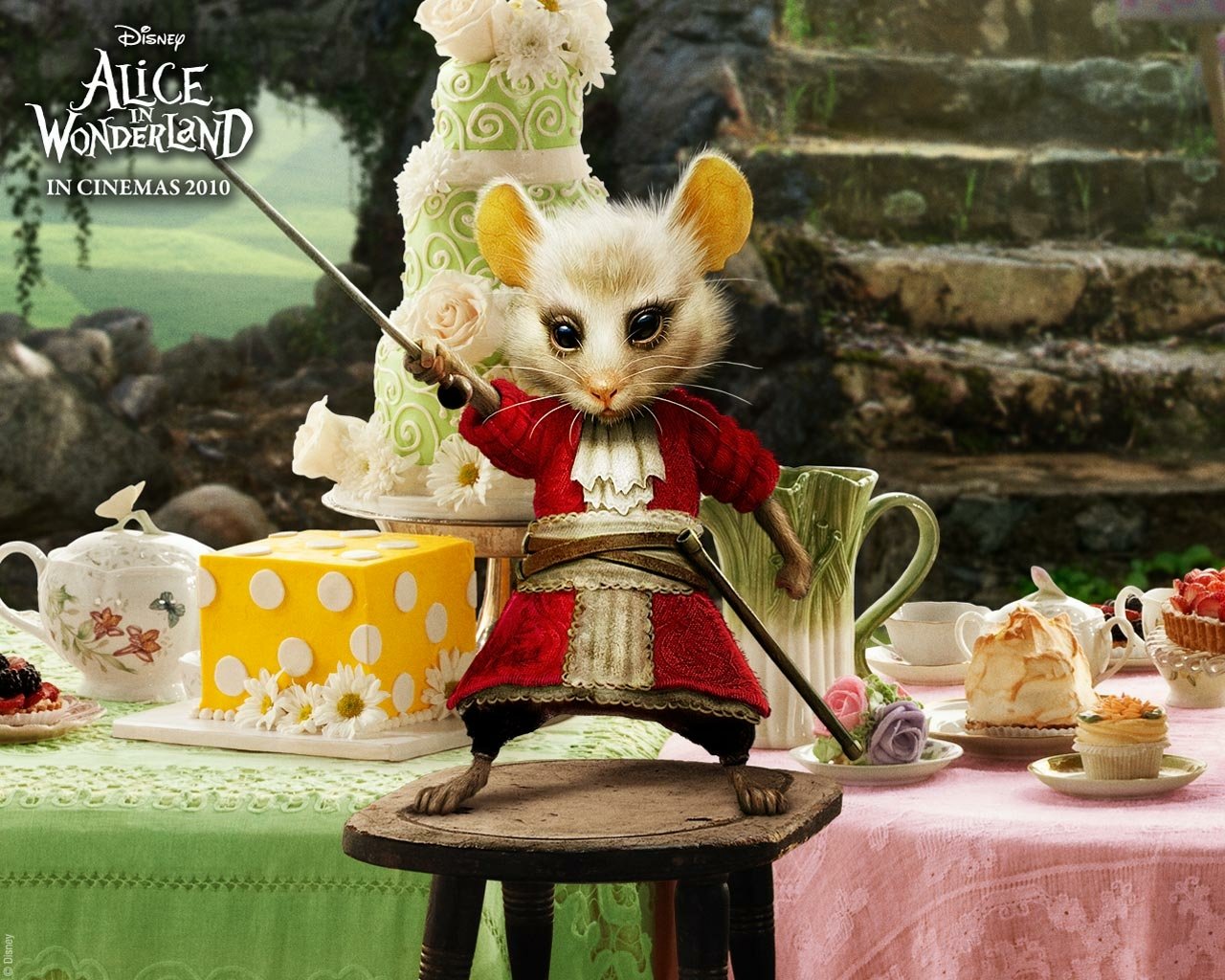 A mouse dressed in a red coat stands on a stool wielding a sword, surrounded by teapots, cake, and pastries, from the movie Alice in Wonderland (2010).