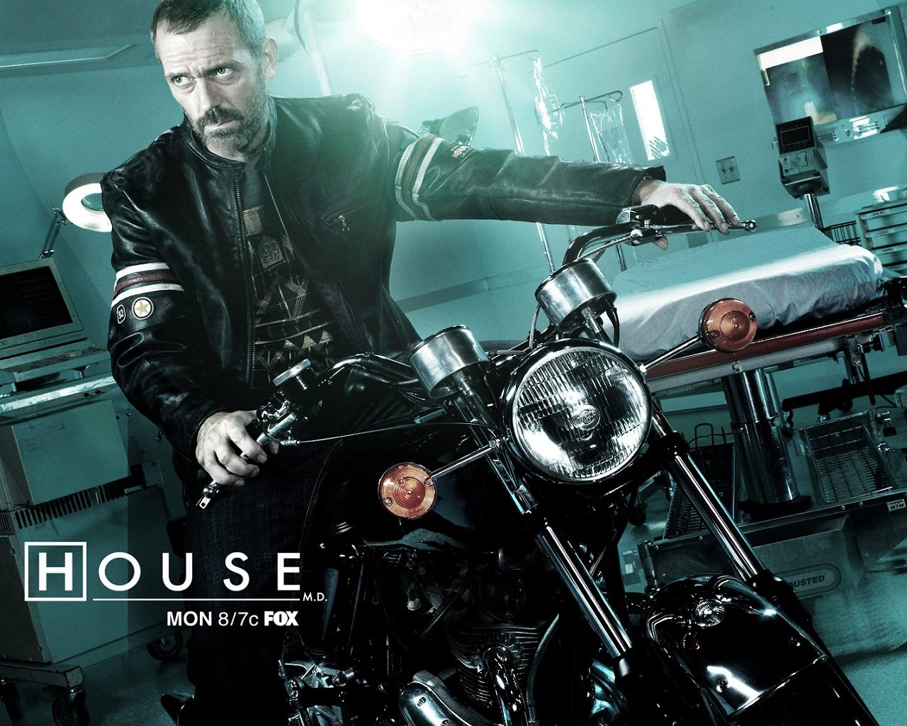 Gregory House from the TV show House sits on a motorcycle inside a hospital room, wearing a leather jacket, cane visible and a grim, intense expression.