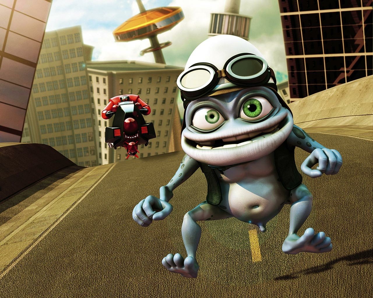 Animated Crazy Frog character wearing goggles and a helmet dances on a city street with DJ equipment in the background, set against tall buildings and a bright sky.