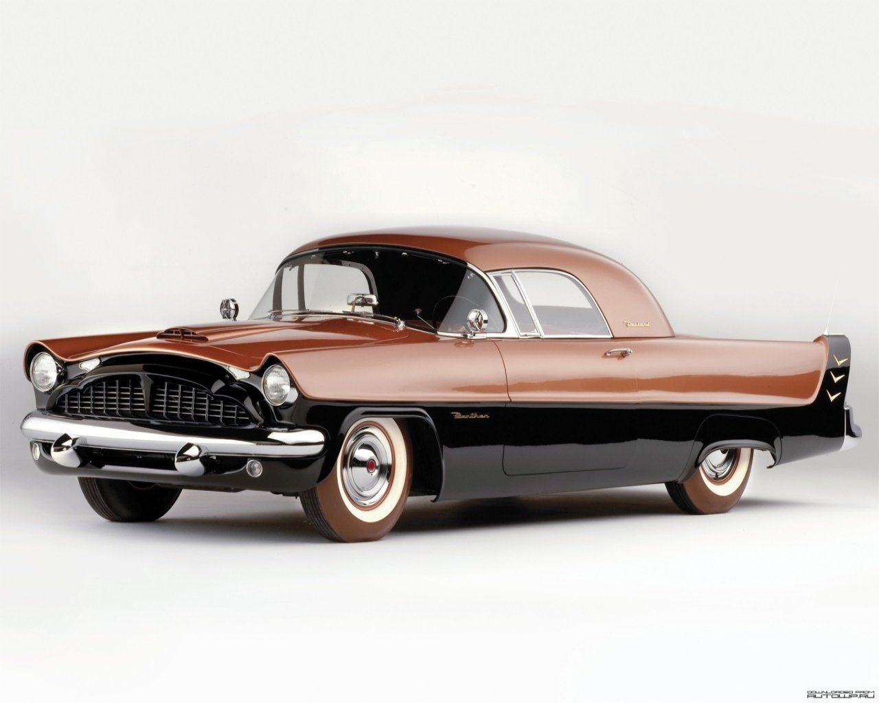 A classic two-tone brown and black Packard vehicle with sleek curves and vintage design elements displayed on a neutral background.