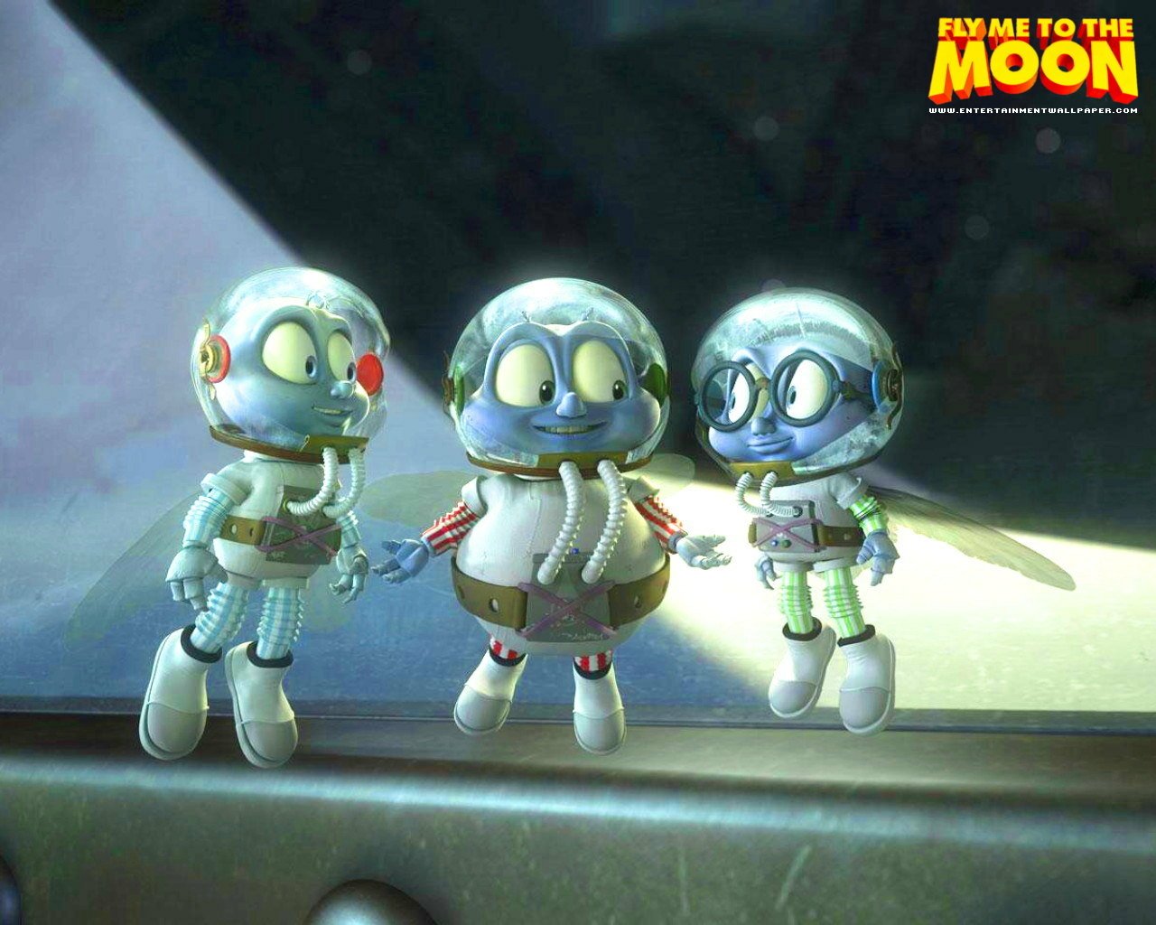 From the movie Fly Me to the Moon: three small helmeted, space-suited characters stand on the Moon under a spotlight, smiling and chatting.
