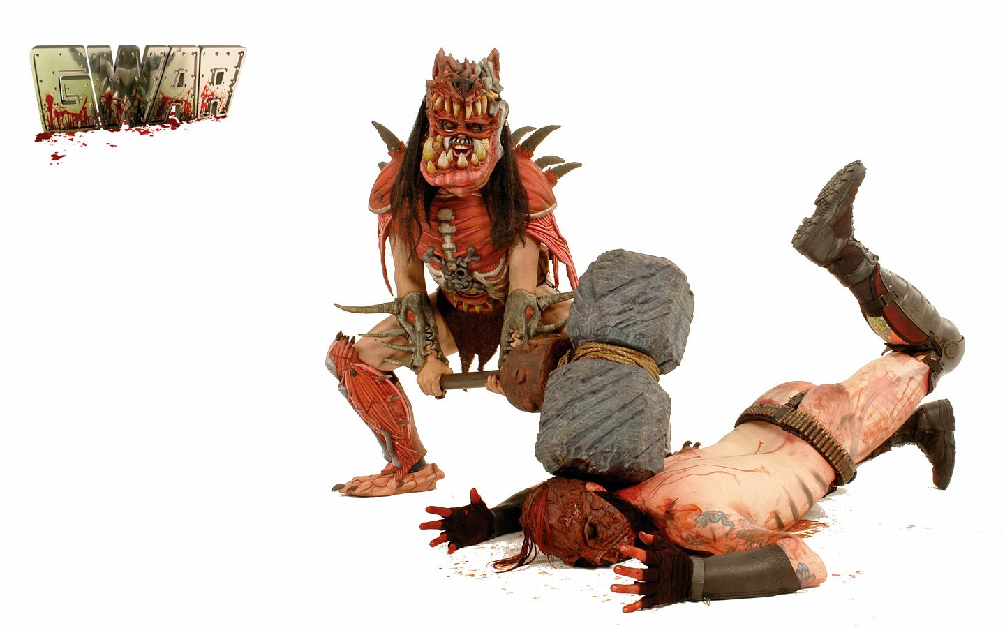 A detailed Gwar music band figure in a demonic costume stands over a fallen armored opponent with a large stone club on a white background.
