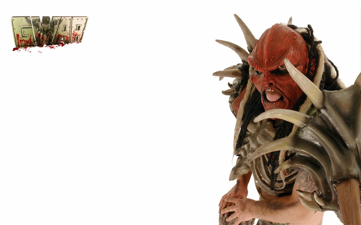 A member of the band Gwar in elaborate, spiked costume and mask, posing fiercely against a white background with the Gwar logo.