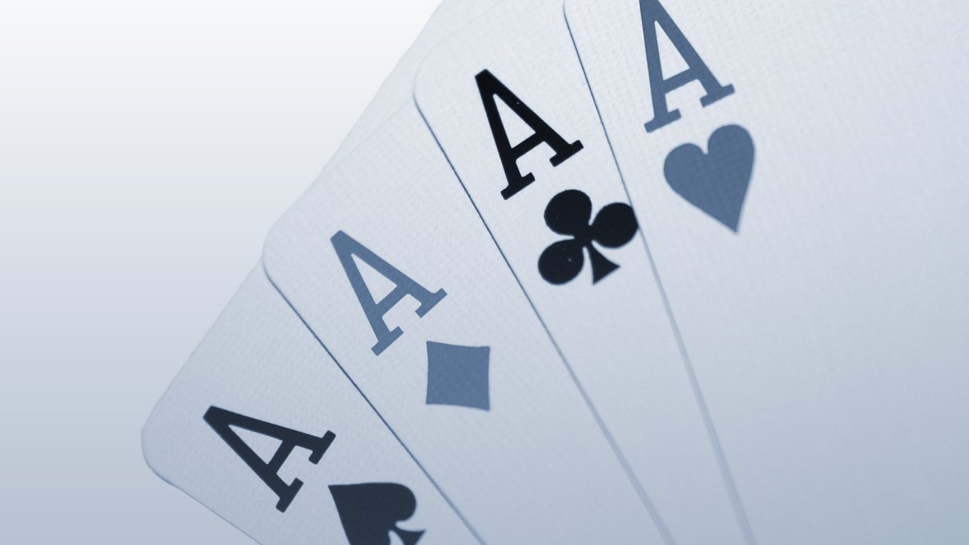 Four playing cards display the letter A in various suits—hearts, diamonds, clubs, and spades—showcasing a man-made design in a clean and modern style.