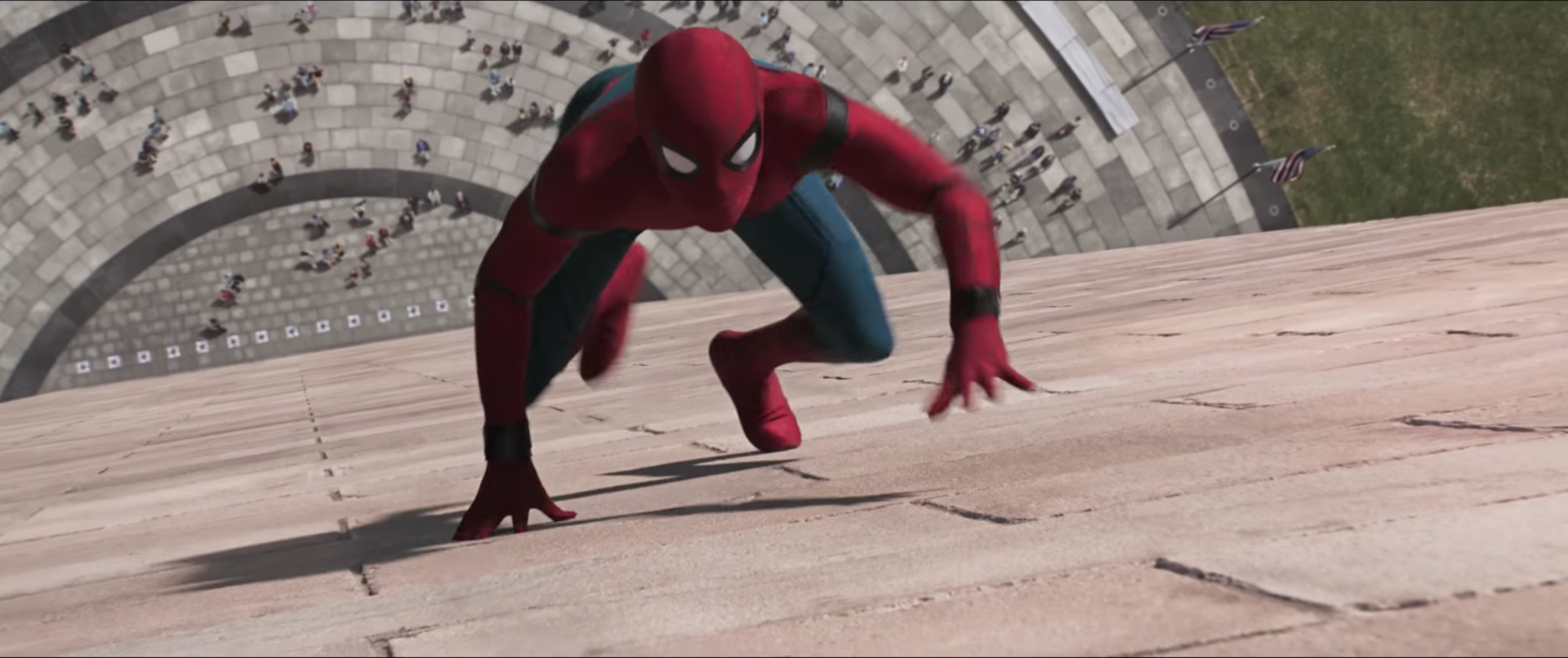 Spider-Man in his red and black suit climbs a tall building in a scene from the movie Spider-Man: Homecoming.