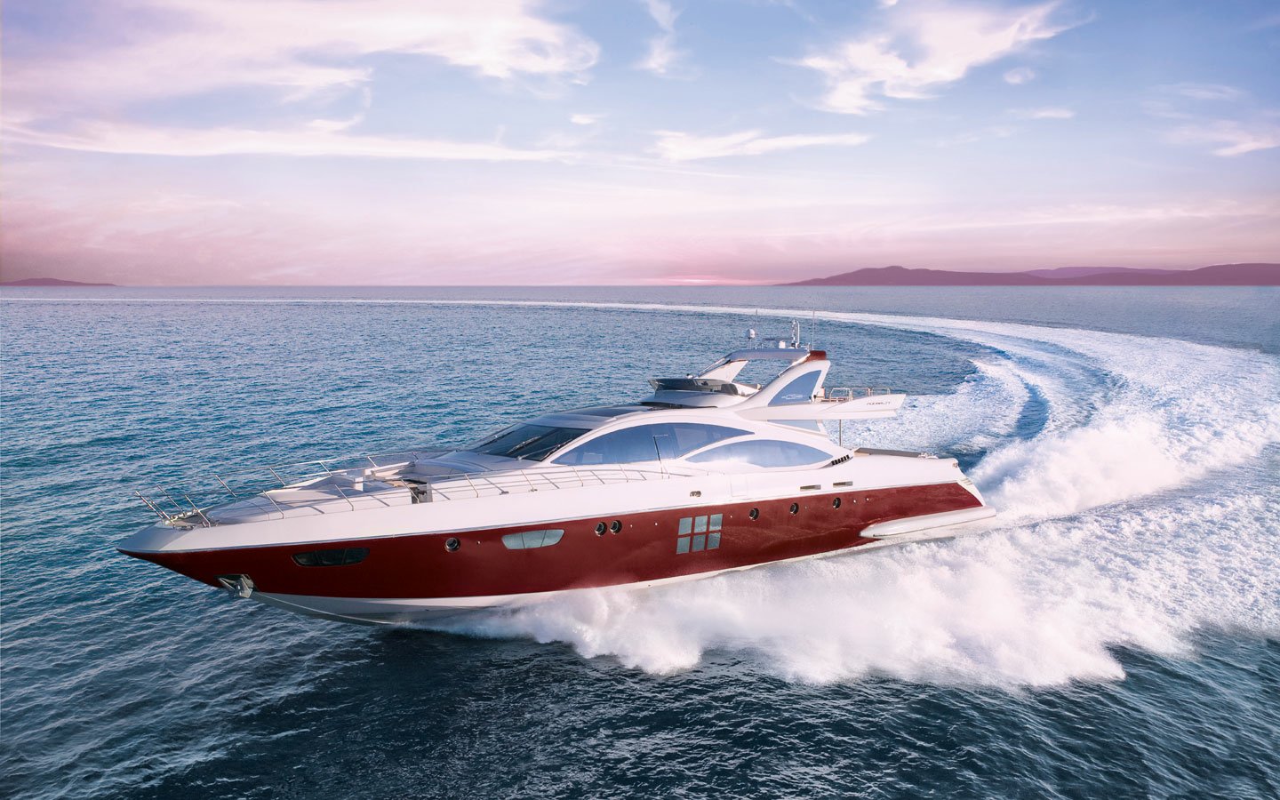 A sleek yacht cuts through shimmering waters, leaving a frothy wake against a backdrop of soft pastel skies. The vessel exudes elegance and speed on the open sea.