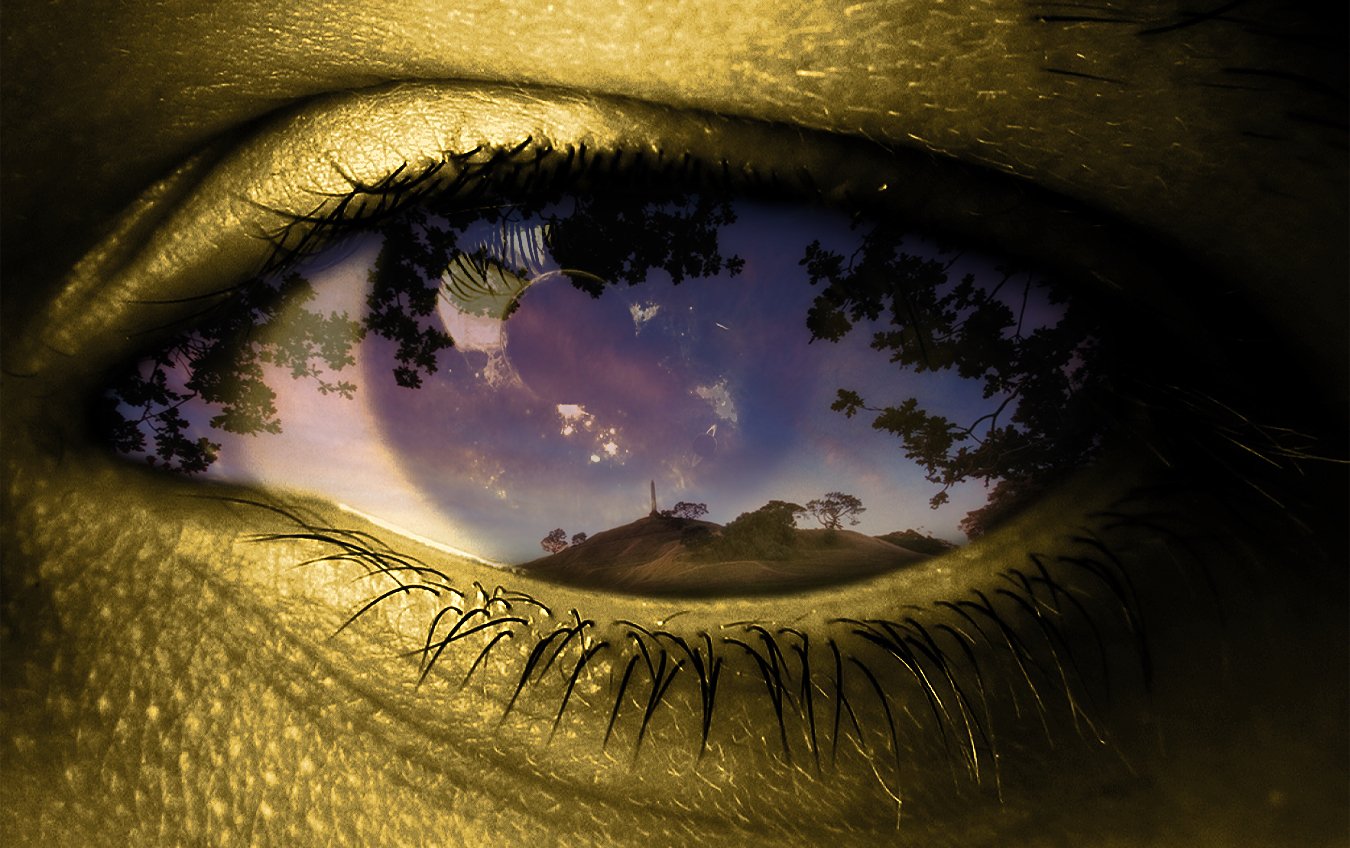 Artistic 3D art — close-up eye containing a surreal sunset landscape with trees, a hill and moon reflected in the iris, skin textures merging with the scene.
