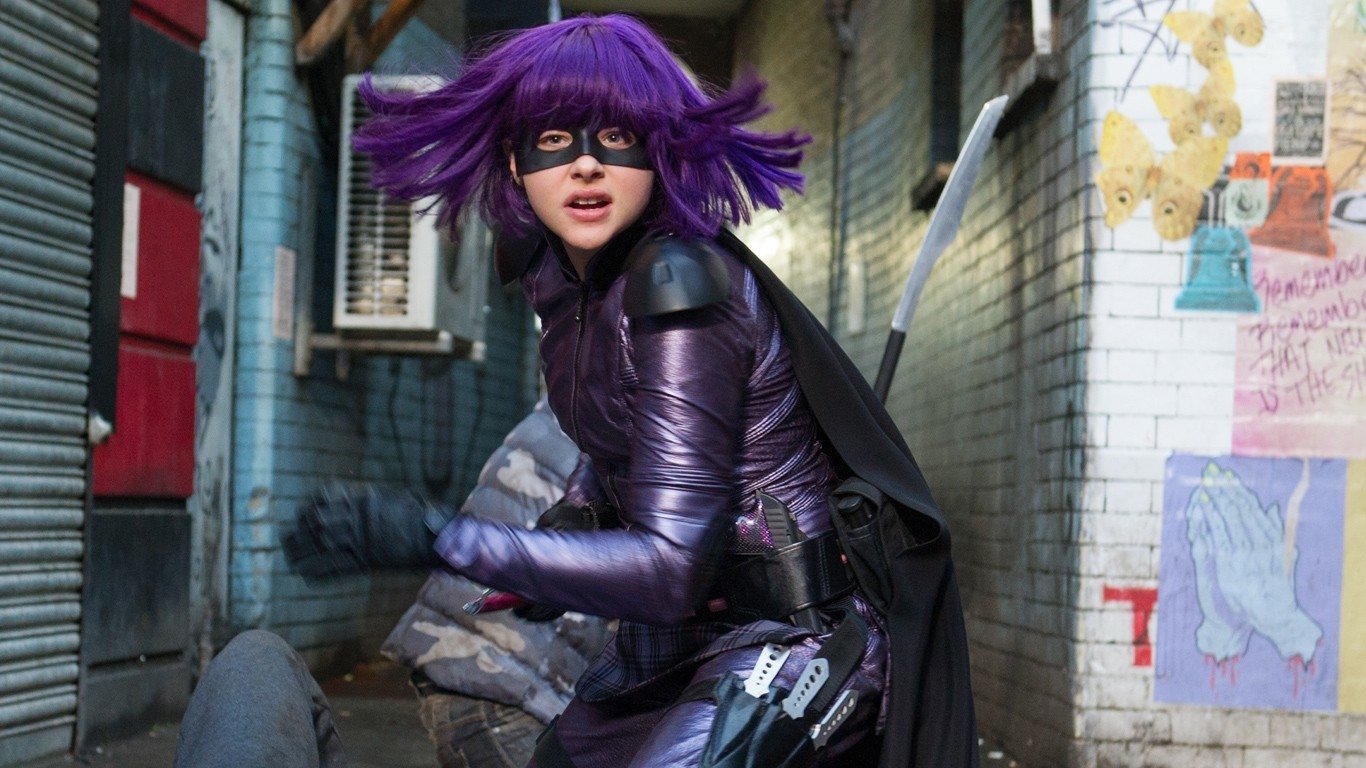 Hit-Girl in her purple costume and mask, ready for action in an alley scene from the movie Kick-Ass 2.