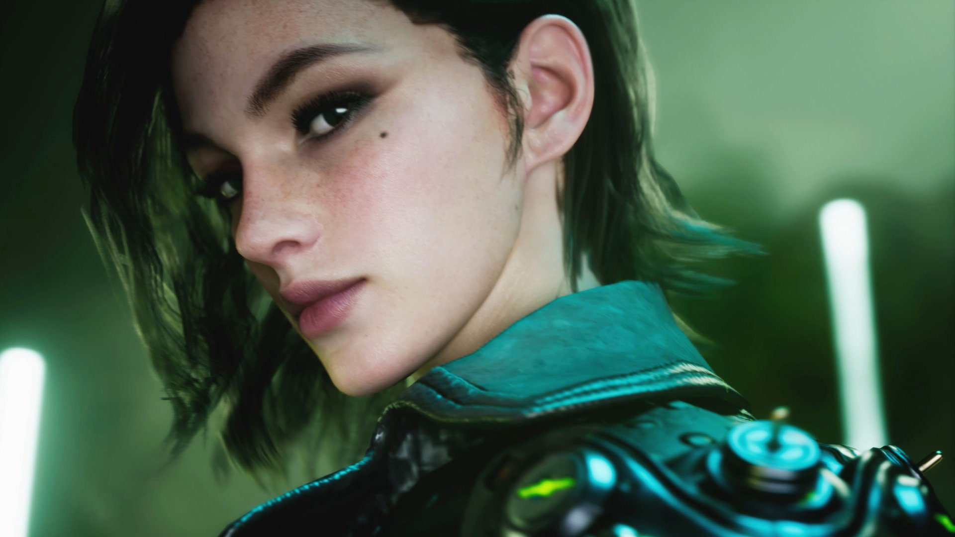 Close-up of a female character from the video game The First Descendant — short dark hair, teal jacket with a cybernetic shoulder, faint cheek mole, moody green lighting.