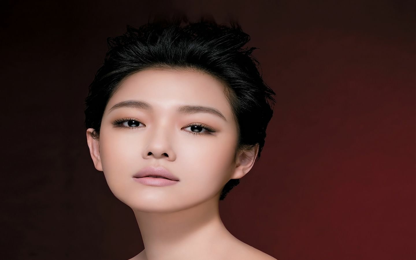Barbie Hsu, a talented Taiwanese singer and actress, poses gracefully with a captivating expression against a rich, dark backdrop.