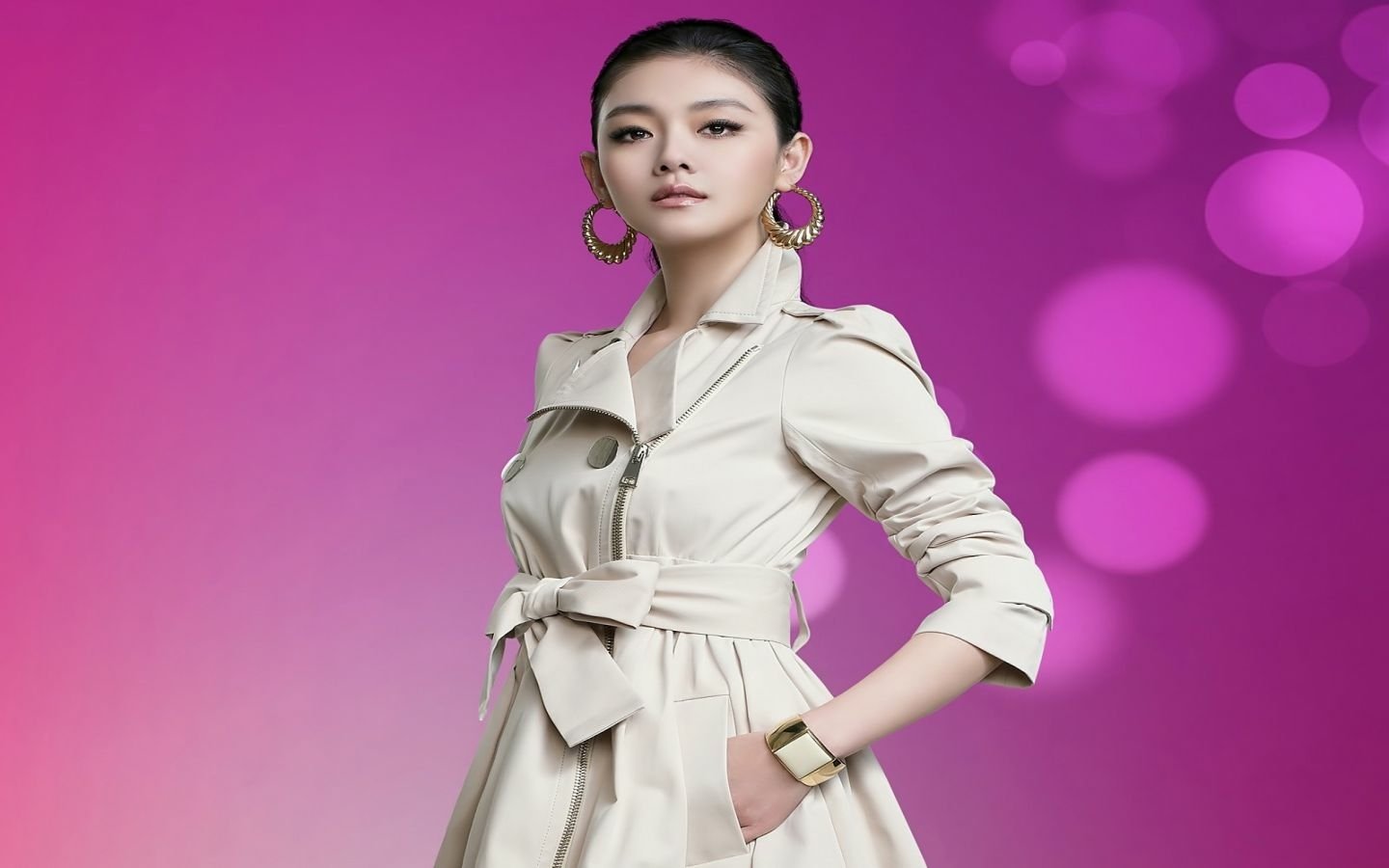 Barbie Hsu, a Taiwanese singer and actress, poses elegantly in a stylish trench coat against a vibrant pink backdrop, exuding confidence and poise.