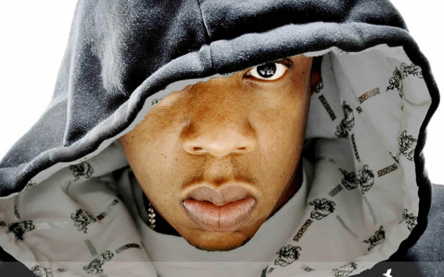 Close-up of Jay-Z wearing a hooded sweatshirt, looking directly at the camera with a serious expression.