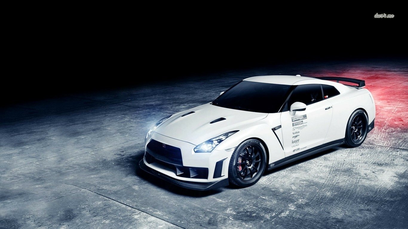 A sleek white Nissan Skyline sports car is parked on a textured surface, showcasing its aerodynamic design and aggressive stance under dramatic lighting.