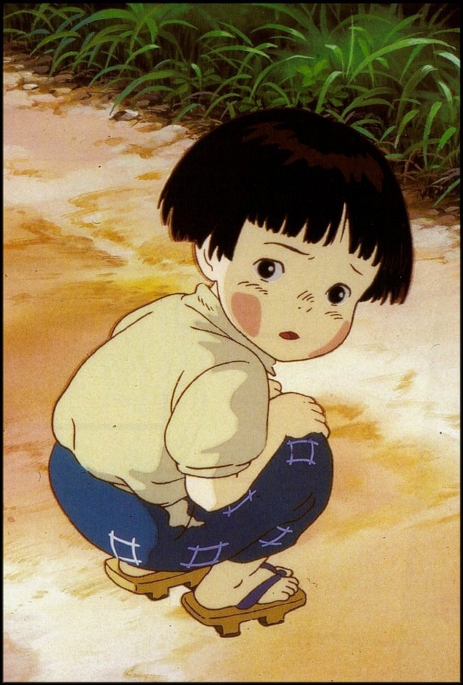 Setsuko Yokokawa from Grave of the Fireflies — a cute anime child crouched on a dirt path, wearing geta sandals, rosy cheeks and a worried expression.