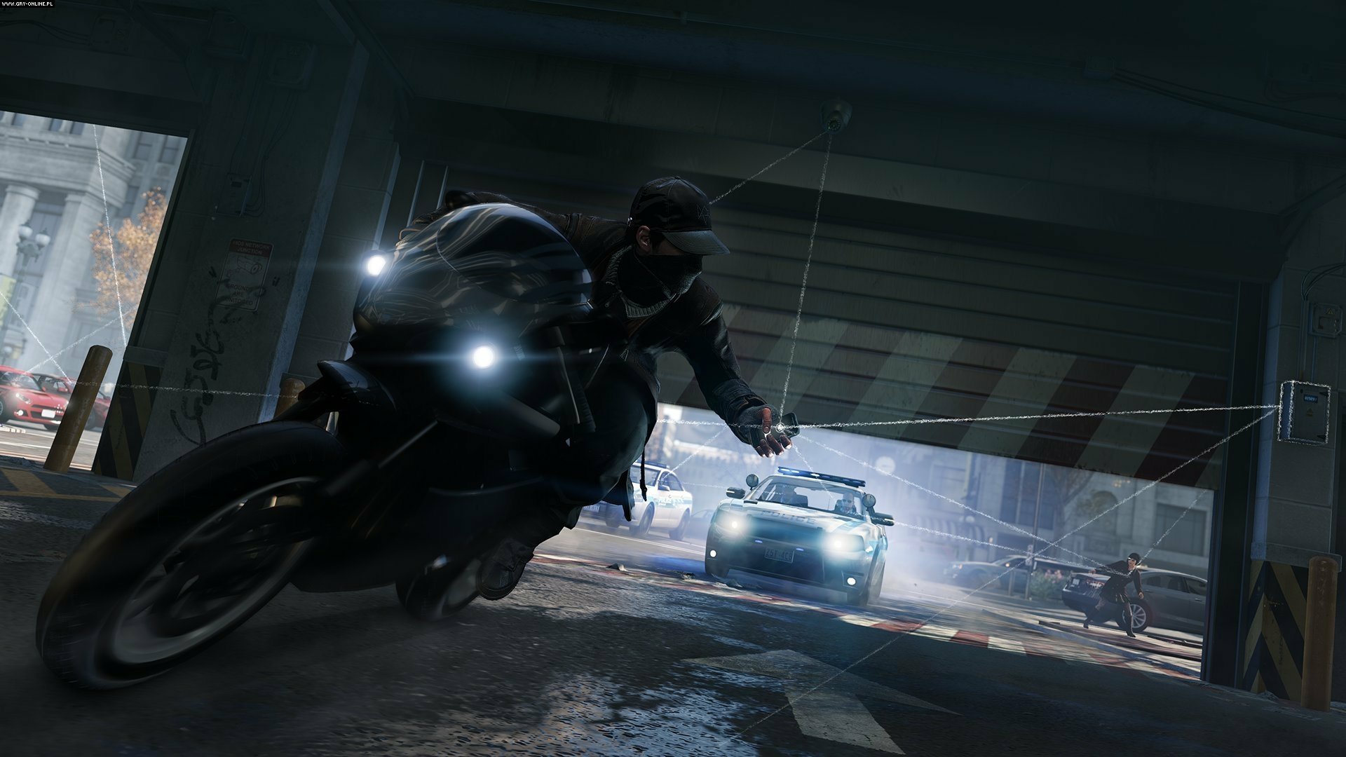 Aiden Pearce rides a motorcycle through a dimly lit urban underpass while being pursued by a car in the video game Watch Dogs.