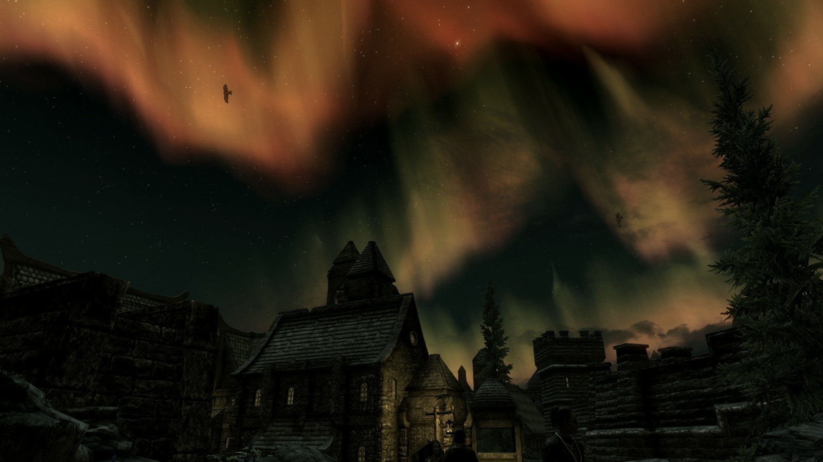 Night sky with vibrant northern lights over a medieval village in The Elder Scrolls V: Skyrim video game.