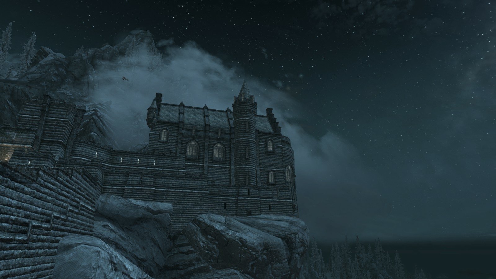 Night scene of a fortress perched on rocky cliffs under a starry sky in The Elder Scrolls V: Skyrim video game.
