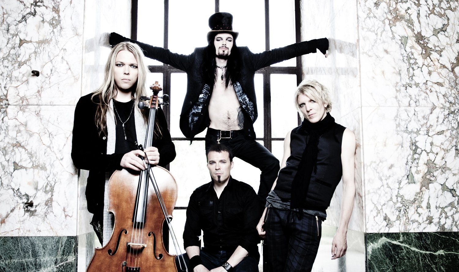 The image features the members of Apocalyptica, a music group, posing with their instruments against a marble wall backdrop.
