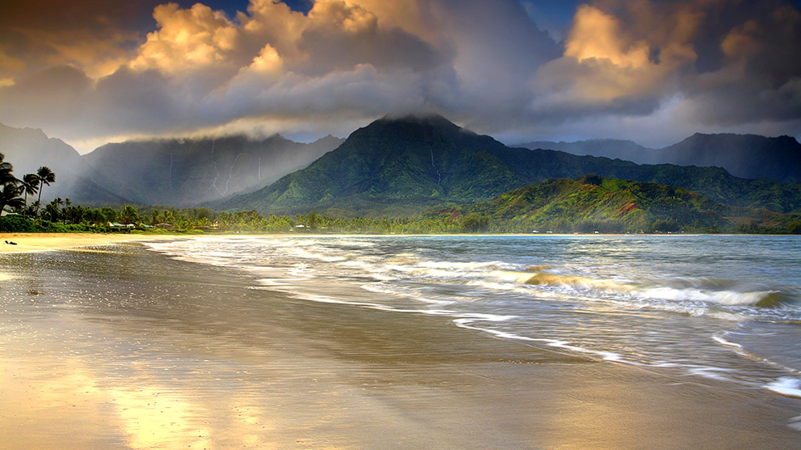 A serene beach in Hawaii captures the beauty of nature, with gentle ocean waves lapping at the shore and dramatic mountains framed by moody clouds in the background.