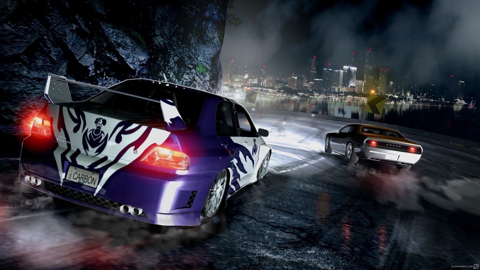 A nighttime street race scene from the video game Need for Speed: Carbon, featuring two customized cars on a wet city road with bright headlights and city lights in the background.