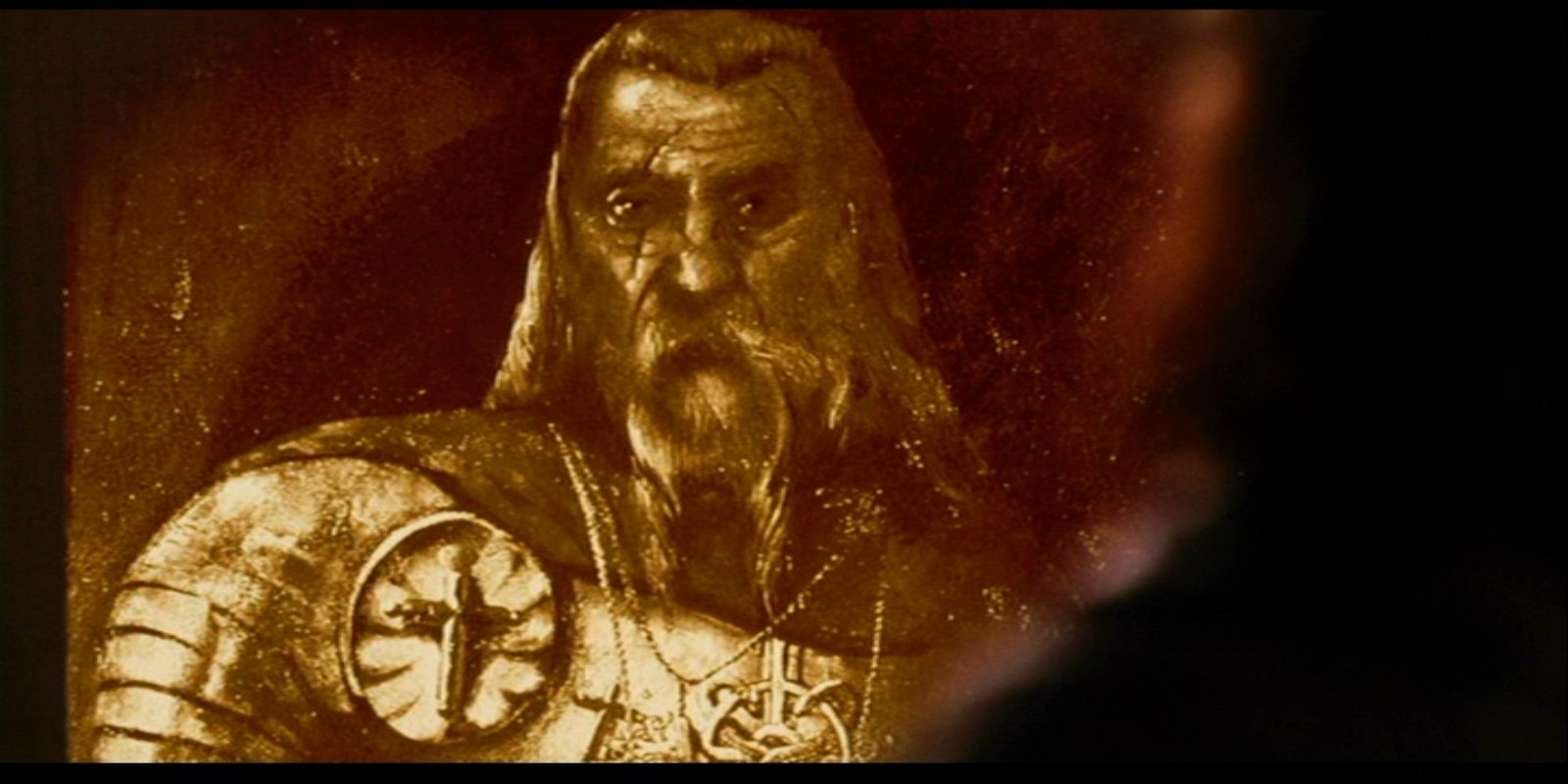 A close-up of a weathered portrait depicting a warrior in armor with a cross emblem, featured in the movie Van Helsing. The expression conveys strength and determination.
