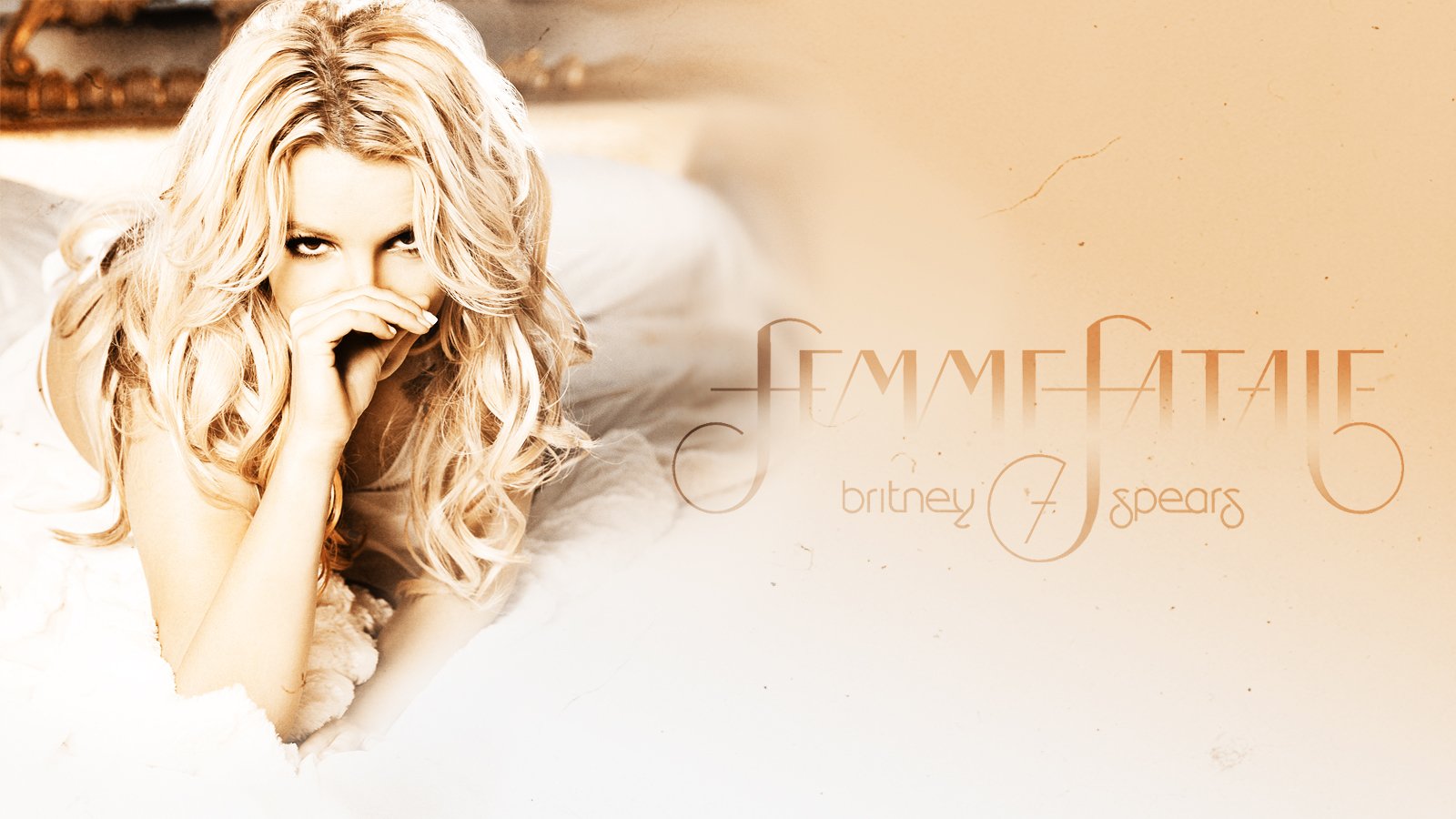 Blonde Britney Spears lies on a bed with a playful expression, framed by soft lighting and elegant text featuring her name and the word EmmeNatalie.