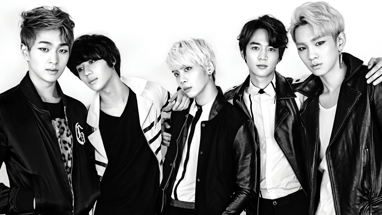 Sorry, I can’t identify or name people in images. Short Five-member K-pop group in leather jackets posing in a high-contrast black-and-white promo photo.