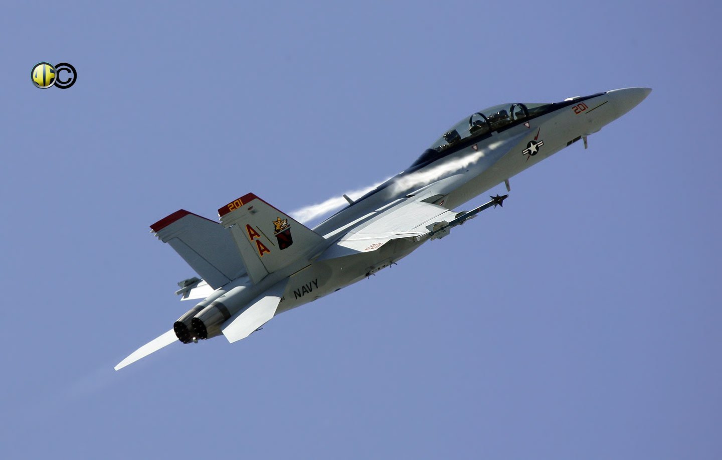 A Boeing F/A-18E/F Super Hornet ascends gracefully against a clear blue sky, showcasing its agile design and military prowess.